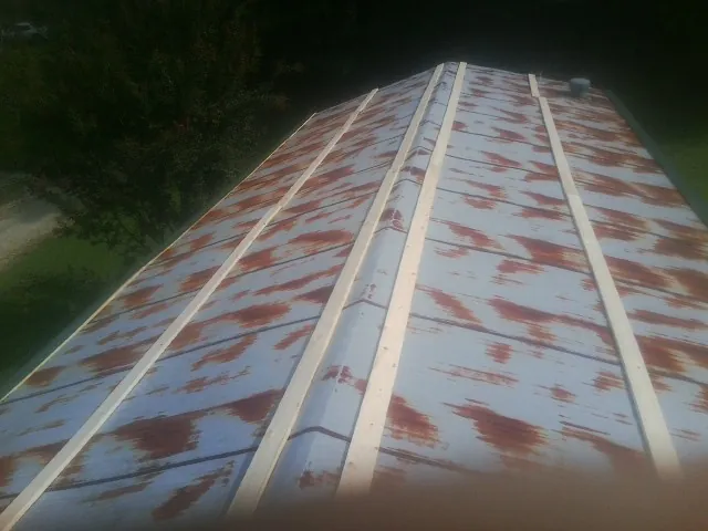 Rusted metal roof panels with new wood purlins before replacement — Storm Damage Roof Repair in Rose by Roofing Brothers