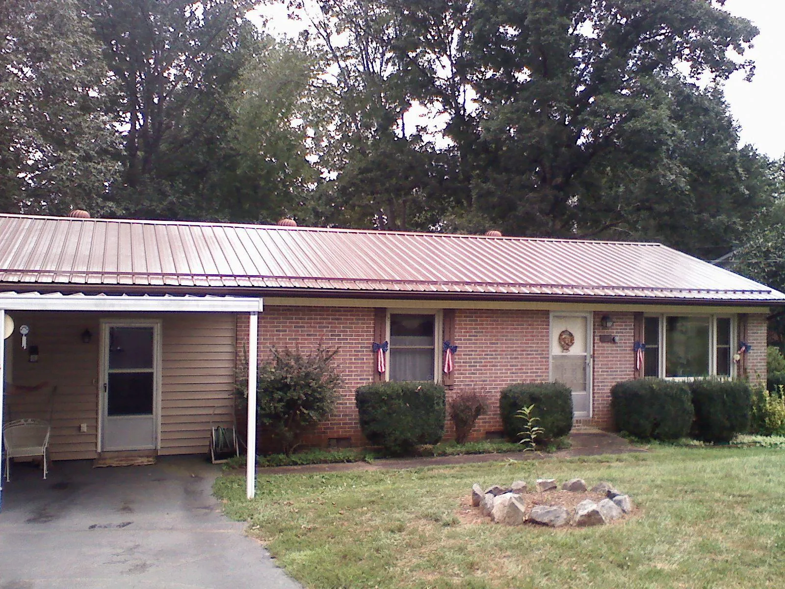 Bronze metal roof and carport on a brick ranch home — Roof Repair work by our crew in Rose